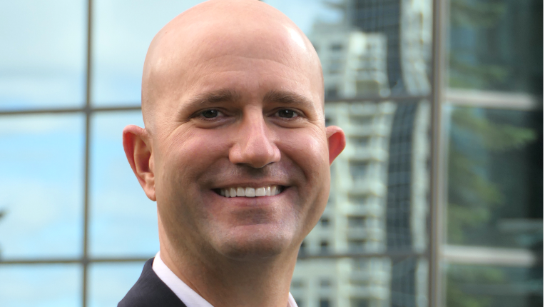 Marvin J. Schmidt smiling against the backdrop of an office building