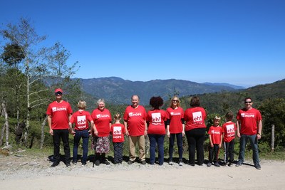 A group of expand hope volunteers standing by a road looking over mountains