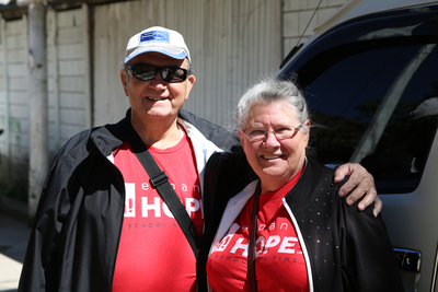 Two Expand hope volunteers standing in front of a car